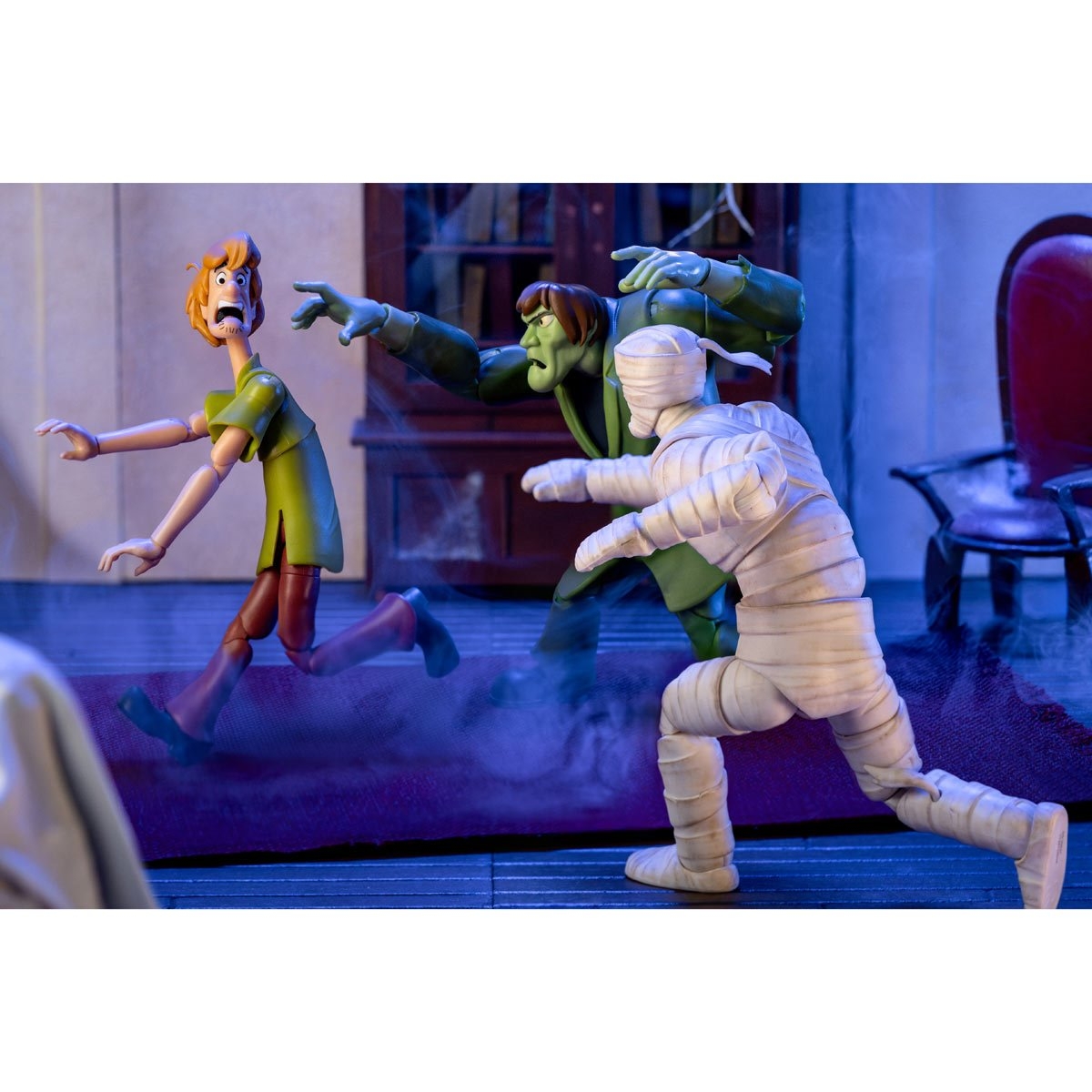 A scene featuring cartoon figures of Scooby-Doo characters, including Shaggy, Frankenstein, and a mummy, in a spooky setting with fog.